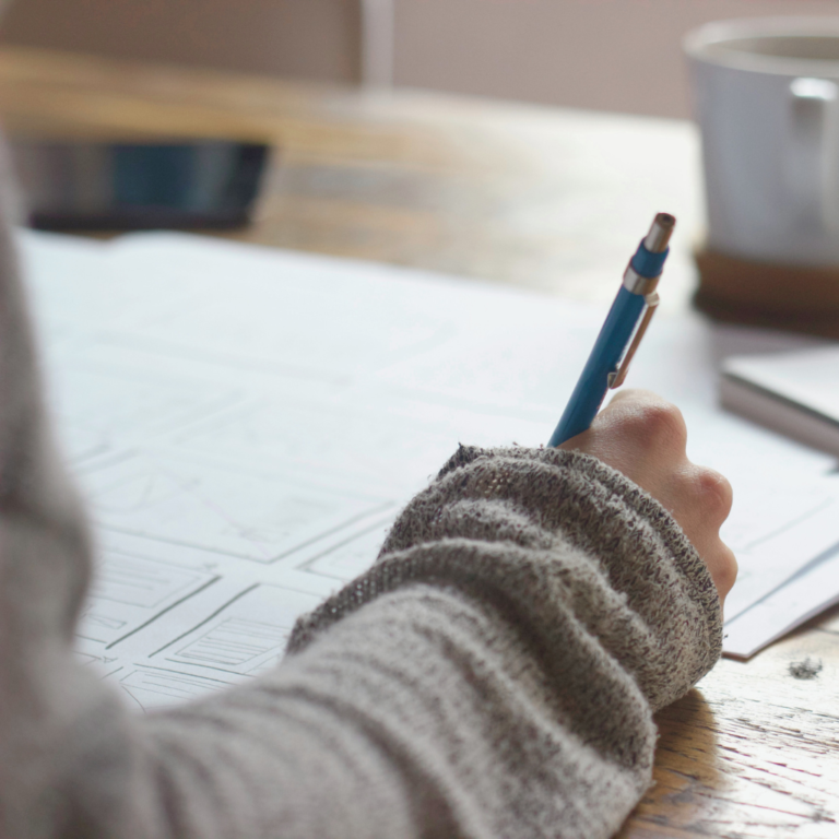 A women writing and planning at her desk.