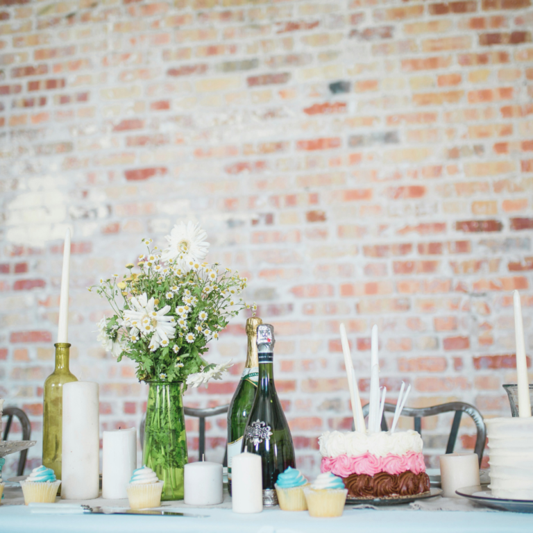 Tablescape of a dinner party with brick background at an end-of-summer party.