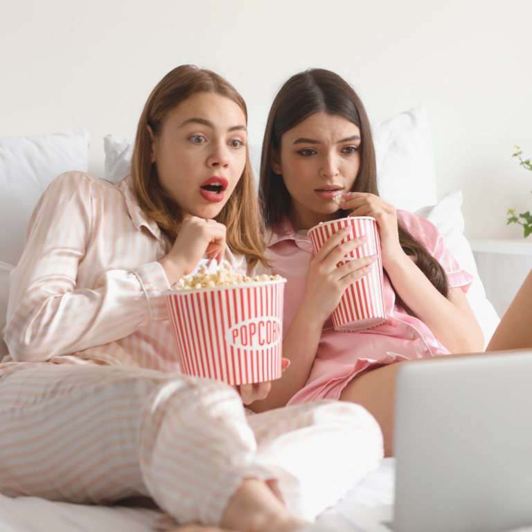 Two girls watching a movie on a laptop in cute birthday pjs.