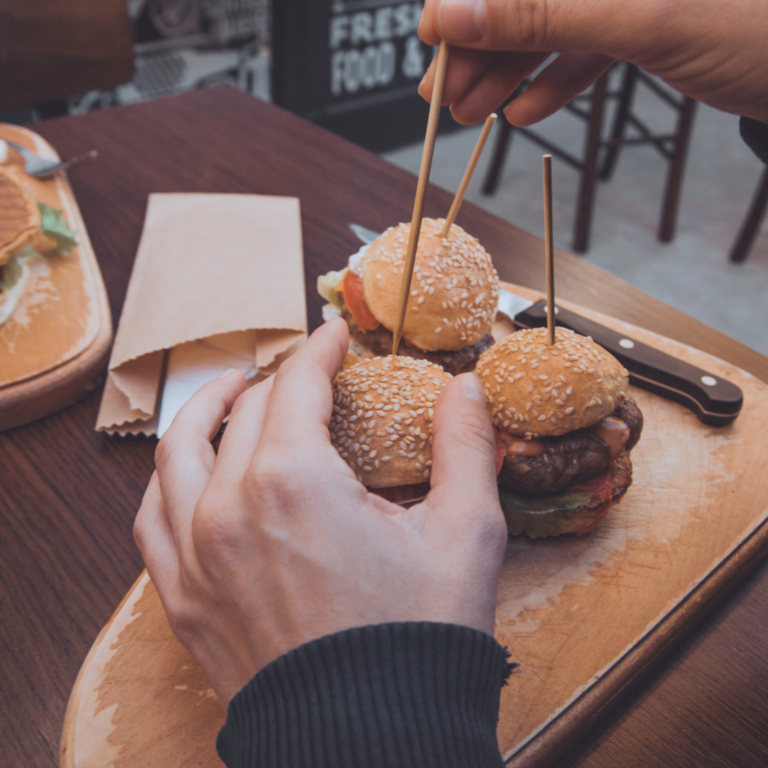 A photo of a man eating a plate of sliders at a PEI pub.