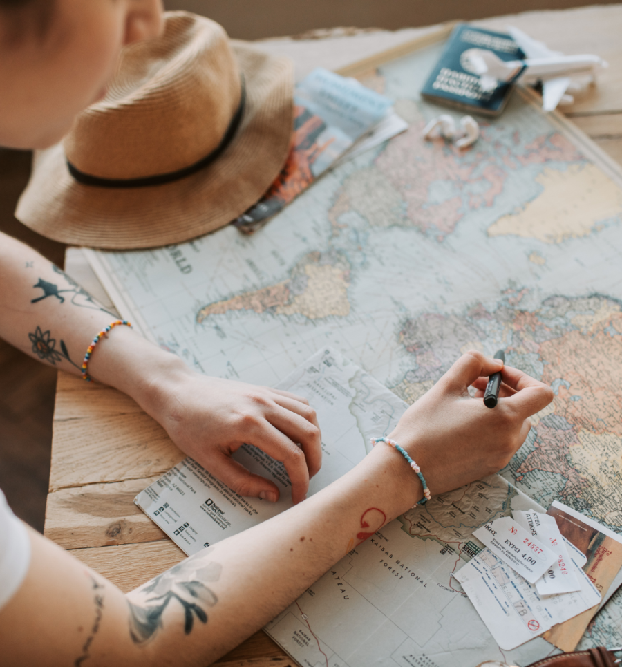 Traveler planning out their travel itinerary via map.